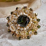 Bague L&rsquo;Oiseau des Iles Vert Argent avec un cabochon Vert sur une estampe Argent&eacute;e orn&eacute;e de cristaux : toupies et chatons. Les perles rondes nacr&eacute;es Ivoire et Olivine compl&egrave;te cette bague r&eacute;glable. 